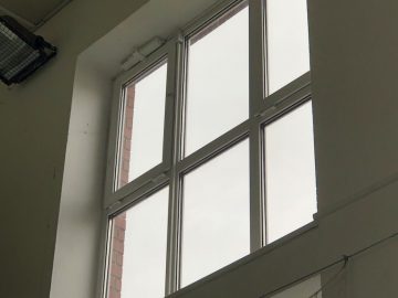 Okna tělocvičny s otvírači oken, zavřené okno